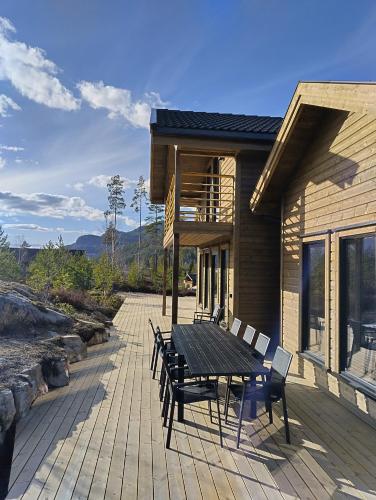 a wooden deck with a table and chairs on a house at Lillelørdag Hytte - Stunning Holiday Home with Sauna in Vradal