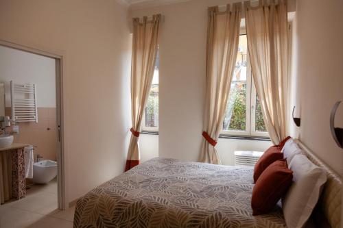 a bedroom with a bed and two windows and a bathroom at Opera 5 in Naples