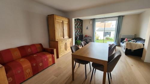 un salon avec une table, des chaises et un canapé dans l'établissement Maison proche centre ville et circuit avec jardin, au Mans