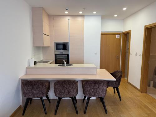 a kitchen with a counter with chairs and a sink at Apartment WOW Budva - With free parking in Budva