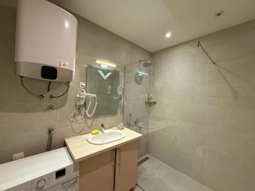 un baño con lavabo y ducha en Apartment WOW Budva - With free parking, en Budva