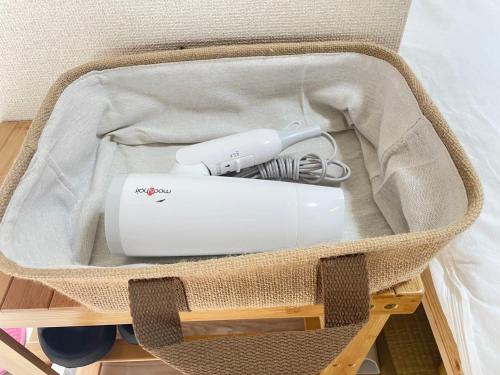 a white appliance in a basket on a table at ying-Shinjuku hostel in Tokyo