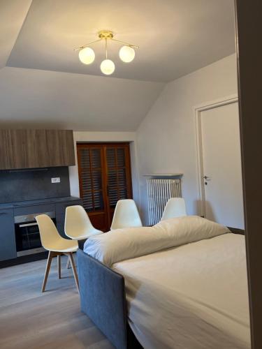 a room with two beds and chairs and a kitchen at Vivic apartment Monforte in Monforte dʼAlba