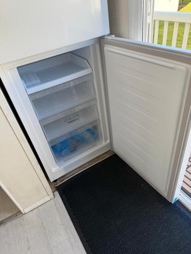 an empty refrigerator with its door open in a kitchen at Willow Way 256 in Camber