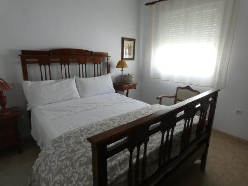 a bedroom with a large bed and a window at Casa Ledo in Casas de Don Antonio
