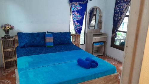 una camera da letto con un letto blu con cuscini blu di Bamboo Hut Resort and Restaurant a Ko Man Nai