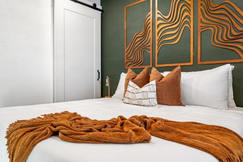 a white bed with an orange blanket on it at The Sandlot Family in Drumheller