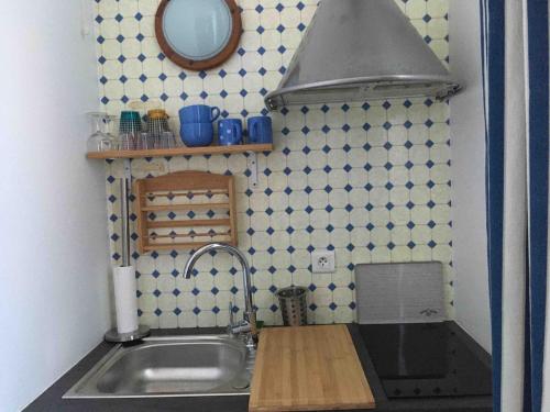 - une petite cuisine avec un évier et un miroir dans l'établissement Studio idéal pour professionnels ou vacanciers, à Saint-Nazaire