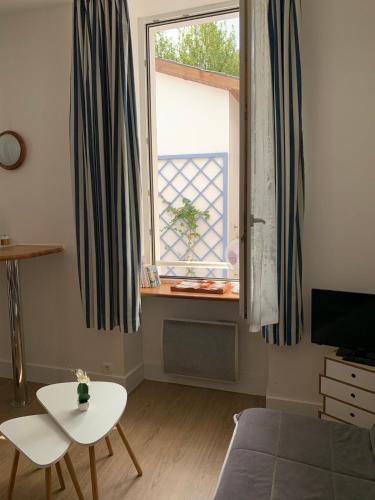 un salon avec une table et une fenêtre dans l'établissement Studio idéal pour professionnels ou vacanciers, à Saint-Nazaire