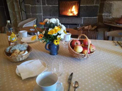 Ferme de la Motte في Le Mesnil-Gilbert: طاولة عليها سلال من الفاكهة والزهور