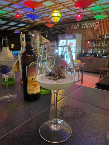 a wine glass sitting on top of a bar at Koh Chang Cabana Resort with swiming pool & BEACH in Ko Chang