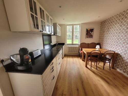 une cuisine avec une table et une salle à manger dans l'établissement Maison de Maitre du 19ème siècle- Honfleur, à Gonneville-sur-Honfleur