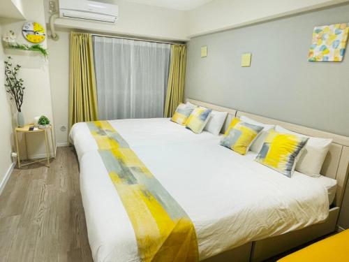 a bedroom with a large bed with yellow and white pillows at ying-Shinjuku hostel-SJ0055 in Tokyo