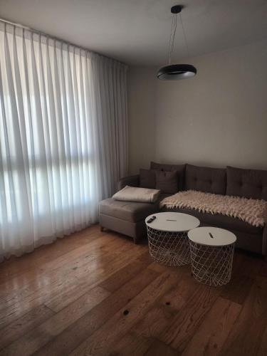 a living room with a couch and two tables at תמר על הים in Bat Yam