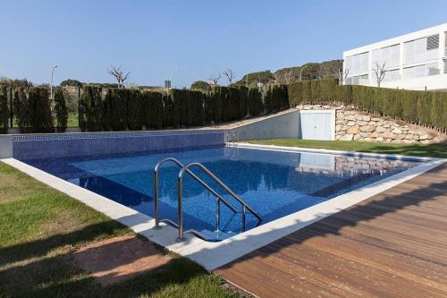 a swimming pool in a yard with a wooden deck at Exclusive Mediterranean Panorama in Sant Pol de Mar in San Pol de Mar