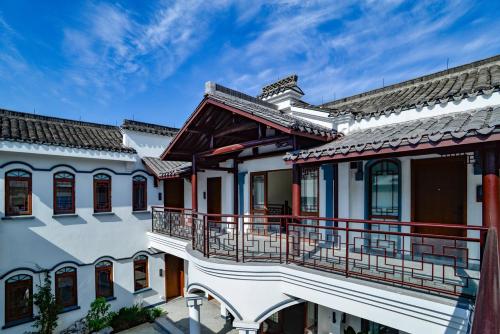 a building with a balcony and a blue sky at Nanxun Boyang New Century Mingting Resort Hotel in Huzhou