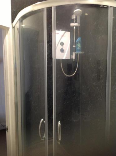 a shower with a glass door in a bathroom at The Beaufort Hunt in Chipping Sodbury