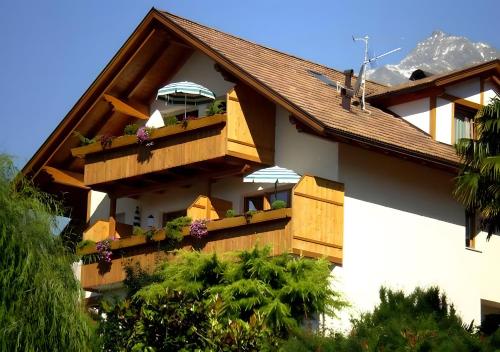 a building with a balcony with flowers on it at Hofanger in Lagundo