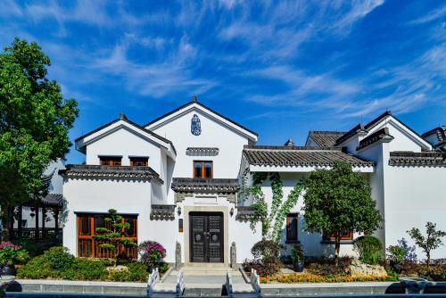 a white house with a black door at Nanxun Boyang New Century Mingting Resort Hotel in Huzhou