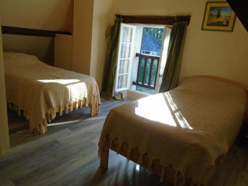 une chambre avec deux lits et une fenêtre dans l'établissement chez MAJOS un HAVRE DE PAIX, à La Celle-sous-Gouzon