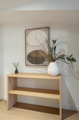 a wooden shelf with a vase with a plant on it at Marina 30 in A Coruña