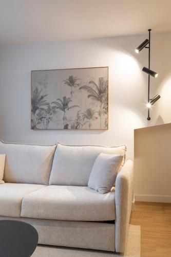 a white couch in a living room with a painting on the wall at Marina 30 in A Coruña