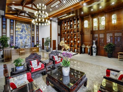 a large lobby with couches and a chandelier at Nanxun Boyang New Century Mingting Resort Hotel in Huzhou