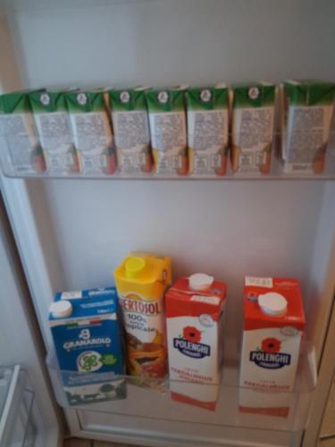 ein Kühlschrankregal mit Milch und anderen Lebensmitteln in der Unterkunft Panariello a Portamedina in Neapel