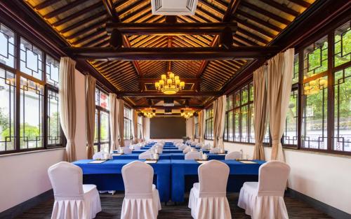 a long banquet hall with blue tables and white chairs at Nanxun Boyang New Century Mingting Resort Hotel in Huzhou