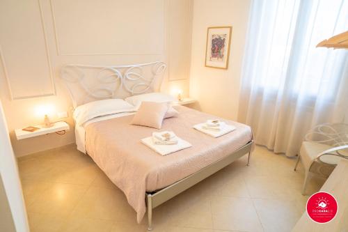 une chambre avec un lit blanc avec deux assiettes dessus dans l'établissement Casa Rosa, à La Spezia