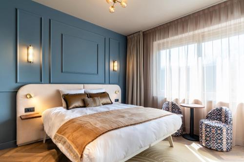 a bedroom with blue walls and a bed with two chairs at Malie House in Utrecht