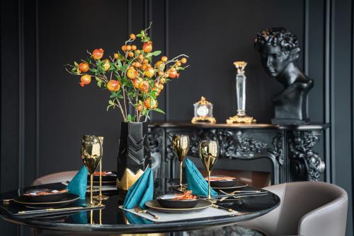 a dining room with a table with a vase of orange flowers at Ascott IFC Guangzhou - Free Shuttle Bus For Canton Fair in Guangzhou