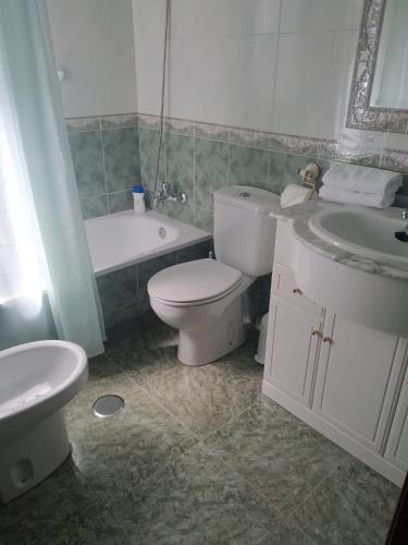 a bathroom with a toilet and a sink and a tub at Casa Ledo in Casas de Don Antonio
