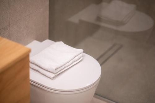 a pile of towels sitting on top of a toilet in a bathroom at Megaro Luxury Suite 7 in Syntagma in Athens