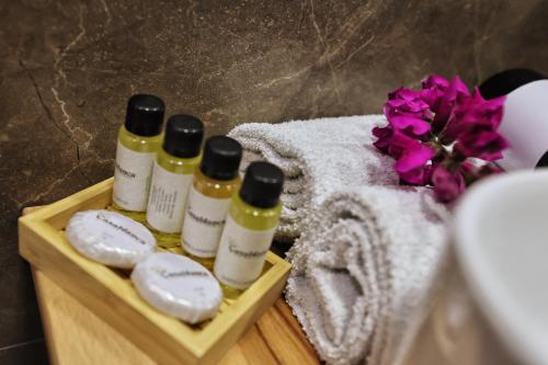 a wooden tray with three bottles of essential oils and towels at Vila Casablanca - Boutique Hotel & Restaurant in Shkodër
