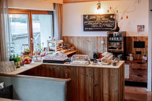 a restaurant with a counter with food on it at Eschenhof Bed & Breakfast in Kaprun