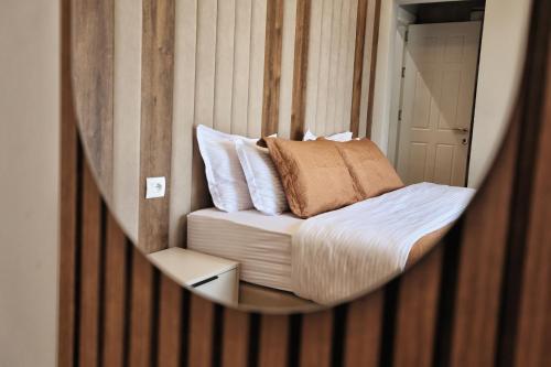 a mirror reflecting a bed in a room at Vila Casablanca - Boutique Hotel & Restaurant in Shkodër
