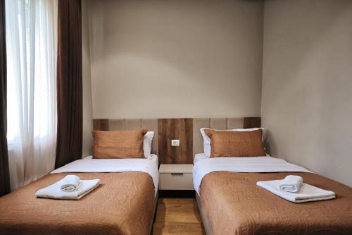 two beds with towels on them in a room at Vila Casablanca - Boutique Hotel & Restaurant in Shkodër