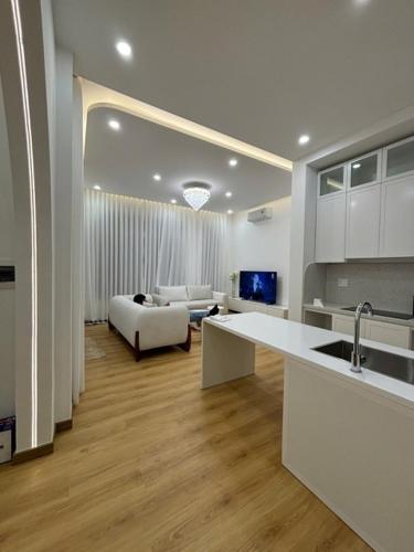 a kitchen and living room with a couch and a table at Our Home in Da Lat