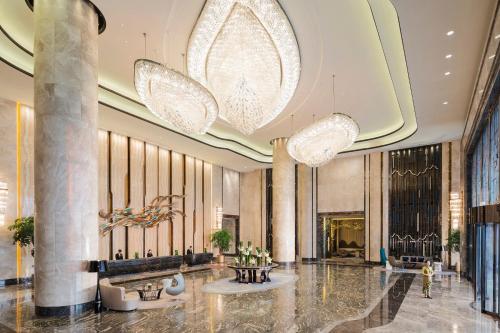 a lobby of a hotel with two chandeliers at Wanda Realm Changzhou in Changzhou