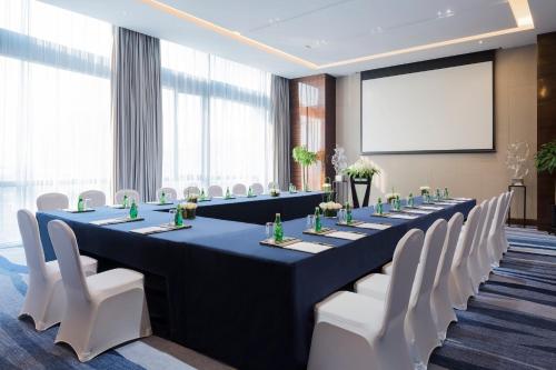 a large meeting room with a long table and white chairs at Wanda Realm Changzhou in Changzhou