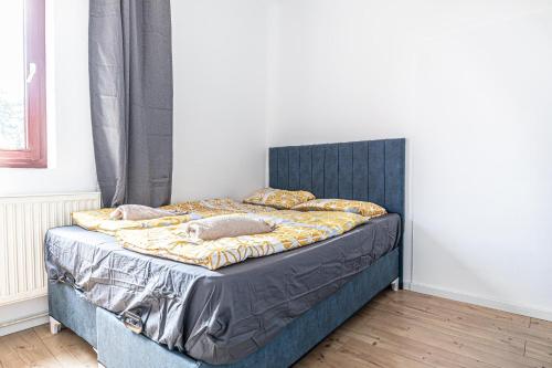 a bed with a blue headboard in a bedroom at Cozy Central 11BR shared Stay with Garden Access & Terrace in Vienna