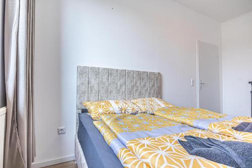 a bed with yellow and blue sheets in a bedroom at Cozy Central 11BR shared Stay with Garden Access & Terrace in Vienna