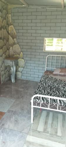 a bed in a room with a stone wall at Panorama in Capalasanan