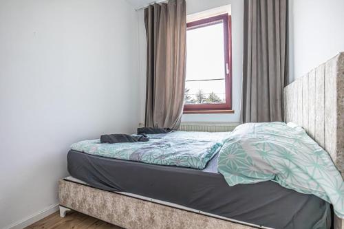 an unmade bed in a bedroom with a window at Cozy Central 11BR shared Stay with Garden Access & Terrace in Vienna