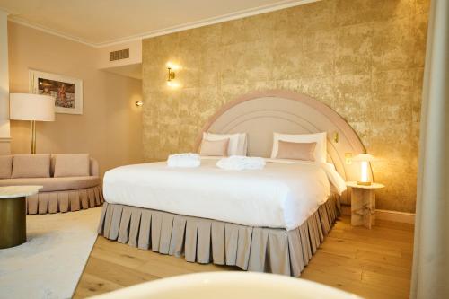 a hotel room with a large bed and a couch at Les Bains de Spa in Spa