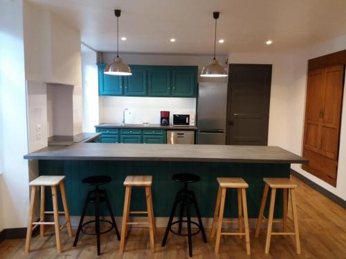 une cuisine avec des placards verts et des tabourets de bar dans l'établissement Kalonjania, à Saint-Martin-dʼArrossa