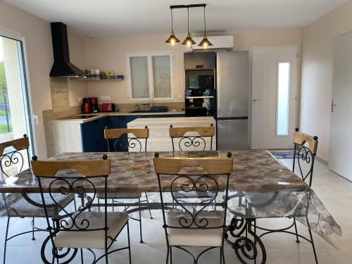 une cuisine et une salle à manger avec une table et des chaises dans l'établissement Gite le Perroquet, à Seigy