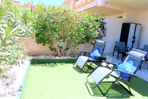 a group of lawn chairs sitting on a patio at Refreshing Oasis in El Médano