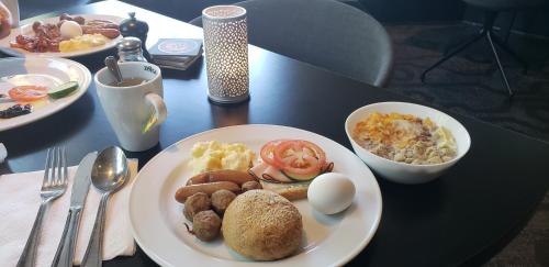 a table with a plate of breakfast food on it at Vingåker Hotell in Vingåker